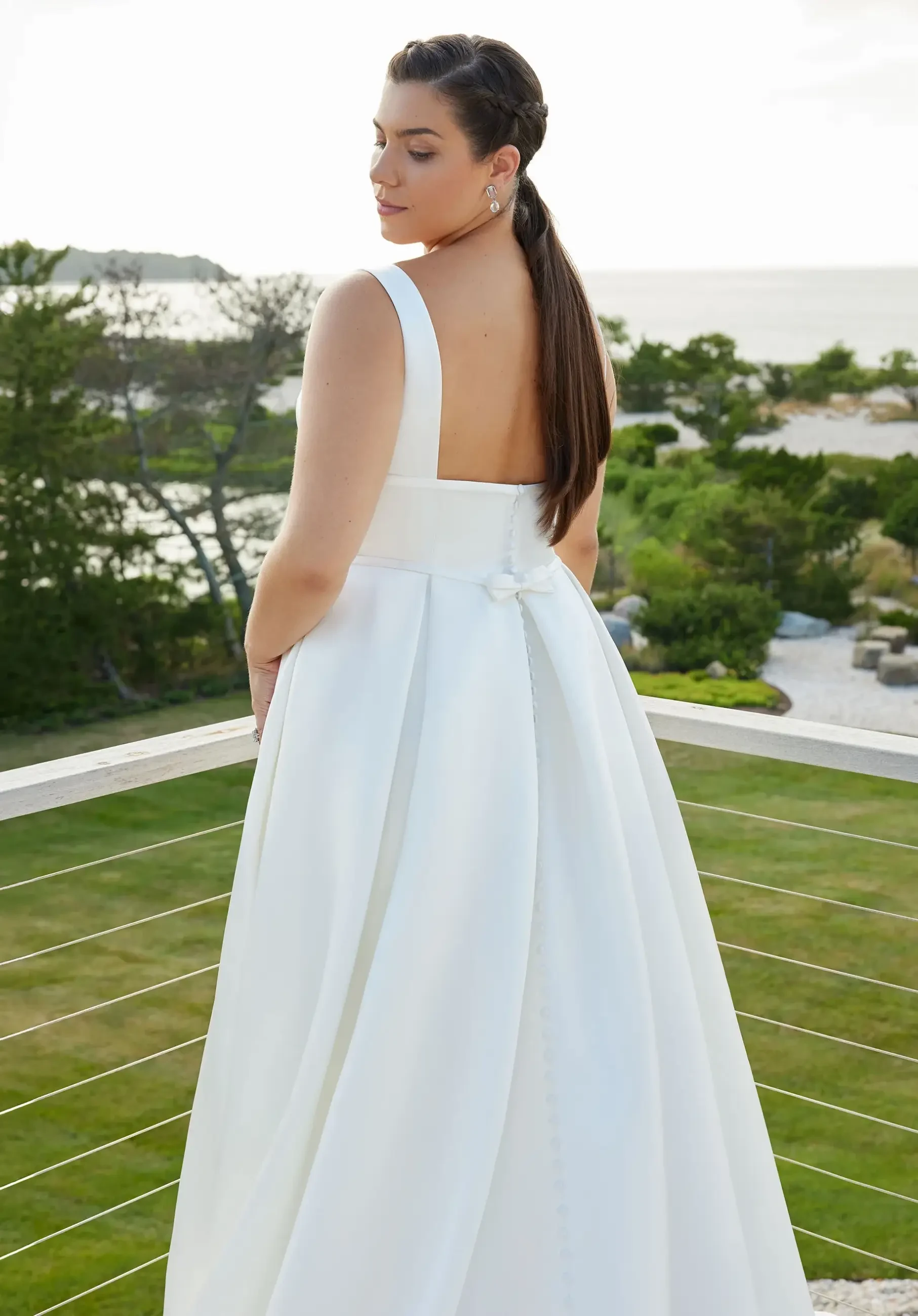 Model is wearing a sleeveless structured a-line wedding dress with a square neckline 