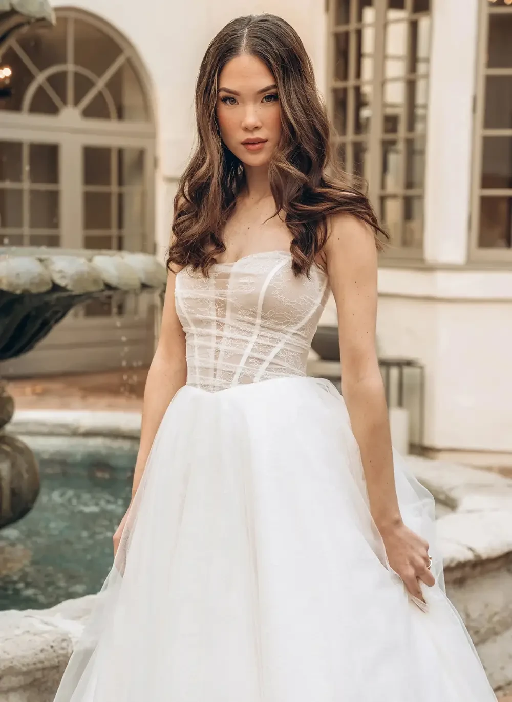 Model wearing a white bridal gown and posing near the men