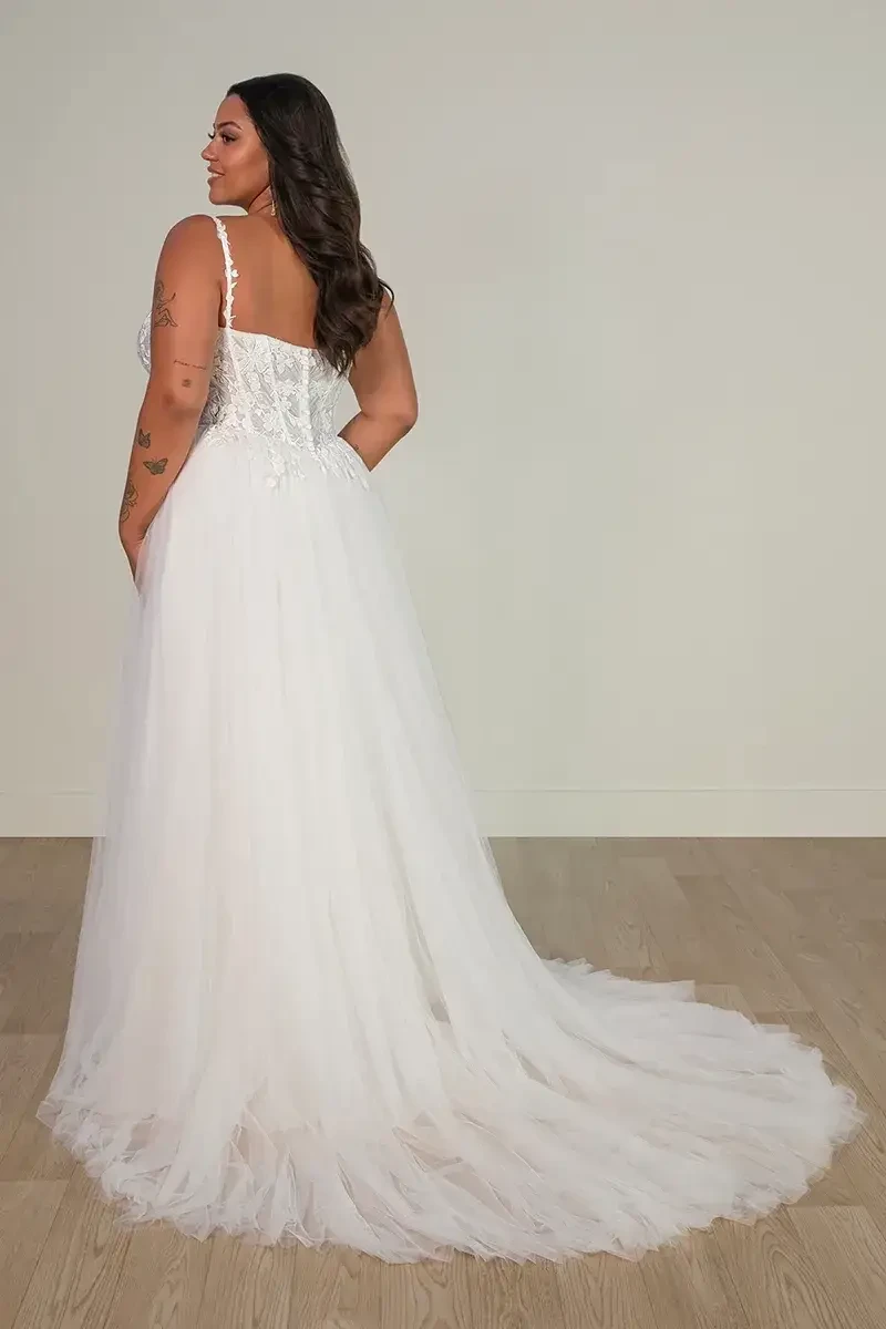 Model is wearing a sleeveless a-line plus size wedding dress 