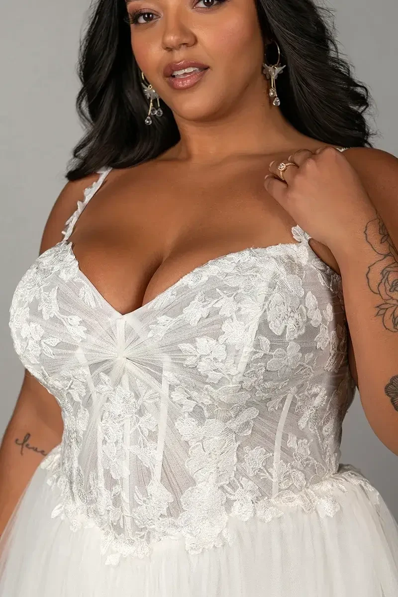 Model is wearing a sleeveless a-line plus size wedding dress 