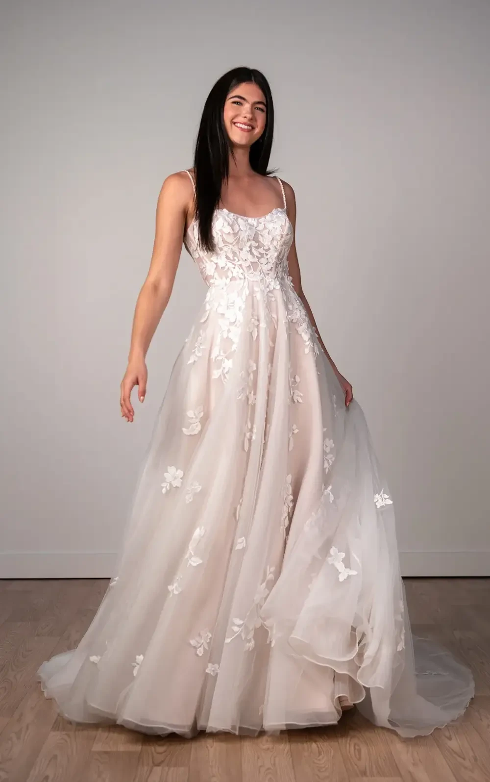model is wearing a sleeveless lace bridal gown