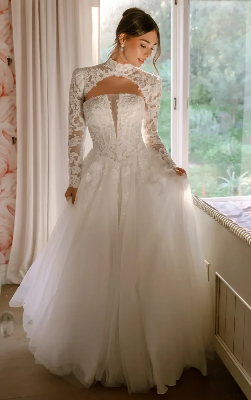 model is wearing a strapless a-line bridal gown with a detachable high neck capelet
