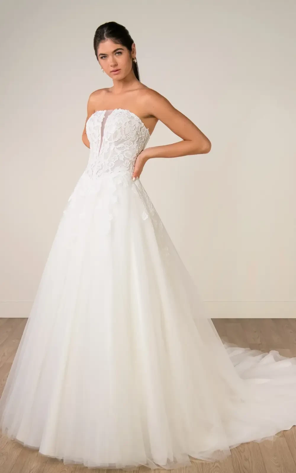 model is wearing a strapless a-line bridal gown with a detachable high neck capelet
